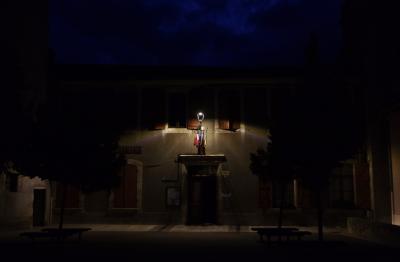 photograph “VIII.2024 — At night” par David Farreny — www.farreny.net — France, Occitanie, Gascogne, Gascony, Gers, Biran, nuit, night, soir, evening, mairie, city hall, place, square, drapeaux, flags, lampe, lamp, lumière, light, bâtiment, building, porte, door, entrée, entrance, arbres, trees, fenêtres, windows, volets, shutters, bois, wood, bancs, benches, ciel, sky, bleu, blue, sombre, dark, nuages, clouds, village