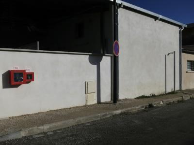 photograph “I.2025” par David Farreny — www.farreny.net — France, Occitanie, Tarn-et-Garonne, Caussade, rue, street, bitume, blacktop, asphalte, asphalt, trottoir, pavement, bâtiment, building, immeuble, mur, wall, béton, concrete, poteaux, poles, posts, panneau, sign, routier, roadsign, interdiction de stationner, no parking, ombre, shadow, gouttière, drainpipe, métal, metal, boîtiers, sécurité, vanne, gaz, coupure générale, gas, safety, boxes, general cut-off, valve