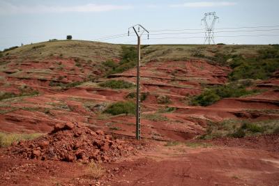 photograph “VIII.2011” par David Farreny — www.farreny.net — France, poteau, électrique, electricity, pole, pylône, pylon, herbe, grass, terre, sol, rouge, red, earth, soil, tas, heap, pile, ciment, cement, métal, metal, arbustes, shrubs, buissons, bushes, colline, hill, vide, empty, emptiness, paysage, landscape, rochers, rocks, Rouergue, Aveyron, Camarès, rougier, Occitanie