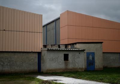 photograph “XI.2009” par David Farreny — www.farreny.net — France, gymnase, gymnasium, gym, métal, metal, bâtiment, building, averse, ondée, shower, pluie, rain, lycée, secondary school, high school, graffiti, arrière, rear, Occitanie, Tarn, Castres, parc, park, Gourjade