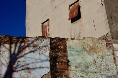 photograph “I.2014” par David Farreny — www.farreny.net — France, mur, wall, pierre, stone, peinture, painting, ombre, shadow, arbre, tree, branches, hiver, winter, bâtiment, immeuble, building, maison, house, volets, shutters, métal, metal, rouille, rust, rusty, câble, fil, cable, wire, angle, coin, corner, ciment, cement, Occitanie, Aveyron, Rouergue, Rodez