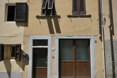 photograph “VIII.2022 — Faces of home, 265” par David Farreny — www.farreny.net — Italie, Italia, Italy, Toscane, Toscana, Tuscany, Arezzo, maison, house, façade, facade, porte, door, fenêtres, windows, volets, shutters, fils, wires, câbles, cables, gouttières, drainpipes, plaque, plate, numéro, number, 23, boîte aux lettres, mailbox, verre, vitre, glass, ombres, shadows, poignée, handle, crépi, roughcast, domicile, home