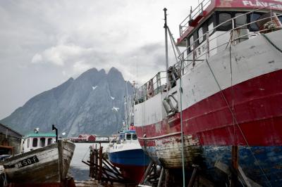 photograph “VII.2017 — Run away to the North, 295” par David Farreny — www.farreny.net — Norvège, Norway, Norge, Norvège du Nord, Nord-Norge, Nordland, Flakstad, Sund, Lofoten, pêche, fishing, port, harbour, harbor, mer, sea, eau, water, montagne, mountain, pic, peak, summit, Ølkontinden, bateaux, boats, nuages, clouds, maisons, houses, bois, wood, rouge, red, cordes, ropes, neige, snow, peinture, paint, bleu, blue