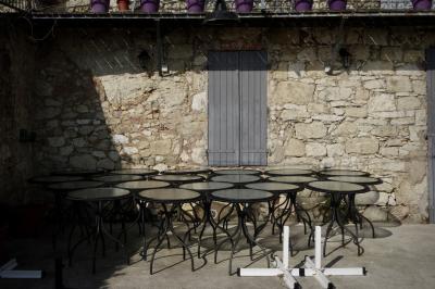 photograph “II.2017 — Out of season” par David Farreny — www.farreny.net — France, Occitanie, Gascogne, Gers, Lavardens, café, bar, restaurant, fermé, closed, hors saison, out of season, hiver, winter, terrasse, terrace, mur, wall, pierre, stone, beige, balcon, balcony, pots, tables, verre, glass, fenêtre, window, volets, shutters, bois, wood, métal, metal, ombre, shadow