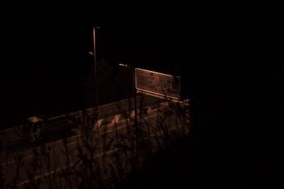 photograph “VII.2023 — Immediate past” par David Farreny — www.farreny.net — Andorre, Andorra, Canillo, soir, evening, nuit, night, sombre, dark, pénombre, darkness, noir, black, route, road, bitume, blacktop, asphalte, asphalt, lampadaire, lamp, camion, truck, lorry, branchages, branches, portique, signalisation, sign, holder, gantry, heure, hour, time, date, jour, day, température, temperature, 22:13, 09/07/23, +21 °C, temps, passé, past, néant, nothingness, dépression, depression