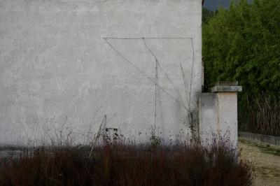 photograph “XII.2020” par David Farreny — www.farreny.net — France, Occitanie, Gard, Saint-Hippolyte-de-Montaigu, maison, house, mur, wall, vegetation, arbres, trees, haie, hedge, câble, cable, fil, wire, métal, metal, bâton, stick, poteau, post, feuillage, foliage, chemin, path, angle, corner, coin, branches, triangle, végétation