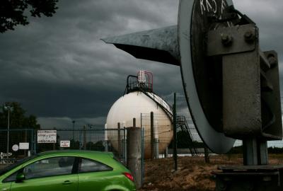 photograph “VII.2011” par David Farreny — www.farreny.net — France, grillage, fence, fencing, voiture, verte, green, car, vert, inscription, writing, panneaux, signs, Entrée et sortie de véhicules, Défense de fumer, portail, gate, réservoir, reservoir, tank, gaz, gas, sphère, sphere, métal, metal, industrie, industry, feu, light, escalier, stairs, steps, marches, écrous, nuts, Occitanie, Aveyron, Rouergue, Ceignac