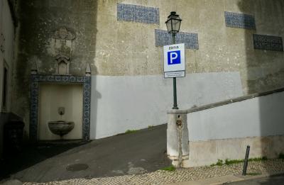 photograph “II.2020” par David Farreny — www.farreny.net — Portugal, Lisbonne, Lisboa, Lisbon, rue, street, trottoir, pavement, ville, city, capitale, capital, pierre, stone, rampe, ramp, parking, car park, zone, zona, panneau, sign, routier, roadsign, bitume, blacktop, asphalte, asphalt, mur, wall, paroi, lampadaire, lamp, fontaine, fountain, angle, coin, corner, ombre, shadow, azulejos, azuléjos, faïence, faience, bleu, blue