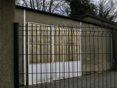 photograph “XII.2024” par David Farreny — www.farreny.net — France, Occitanie, Gascogne, Gascony, Auch, hangar, shed, portail, gate, métal, metal, clôture, fence, mur, wall, ciment, cement, rugueux, rough, arbres, trees, branches, branchages, tôle ondulée, corrugated iron, doré, golden, toit, roof