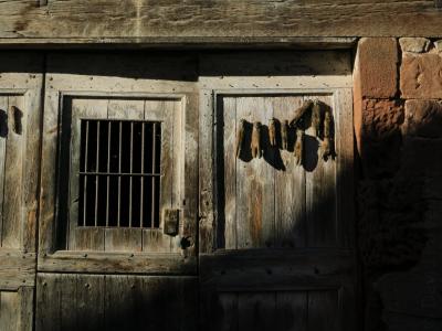 photograph “VI.2012” par David Farreny — www.farreny.net — France, porte, door, bois, wood, grille, bars, métal, metal, mur, wall, pierre, stone, linteau, lintel, pattes, paws, animal, animaux, animals, sangliers, boars, porcs, pigs, hogs, campagne, countryside, ombre, shadow, Occitanie, Aveyron, Rouergue, Marcillac-Vallon