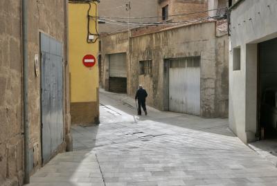 photograph “V.2023” par David Farreny — www.farreny.net — Espagne, España, Spain, Catalogne, Cataluña, Catalunya, Barcelone, Barcelona, Bages, Cardona, rue, street, maisons, houses, ciment, cement, mur, wall, fenêtres, windows, béton, concrete, pierre, stone, garages, portails, gates, métal, meta, câbles, cables, fils, wires, gouttière, drainpipe, panneau, sign, routier, roadsign, sens interdit, one way, homme, man, vieux, vieil, old, passant, passer-by, piéton, pedestrian, canne, cane, stick, carrefour, crossing, angle, coin, corner, ruelle, alley, brique, brick, toit, roof, tuiles, tiles, dépression, depression