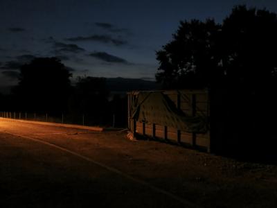 photograph “VIII.2013 — At night” par David Farreny — www.farreny.net — France, nuit, night, soir, evening, benne, skip, conteneur, container, métal, metal, rue, street, clôture, fence, grillage, fencing, nuages, clouds, arbres, trees, bâche, cover, sheet, trottoir, pavement, Occitanie, Aveyron, Rouergue, Olemps