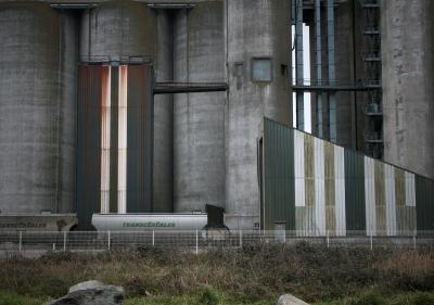 photograph “I.2010” par David Farreny — www.farreny.net — France, Nantes, Loire-Atlantique, Pays de la Loire, silos, entrepôts, warehouses, magasins, hiver, winter, vent, froid, cold, wind, grillage, fence, fencing, tôle ondulée, corrugated iron, métal, metal, béton, concrete, industrie, industry, vertical, train, wagons, céréales, cereal, escaliers, stairs, passerelle, footbridge, parallèles, parallels, rouille, rust, rusty