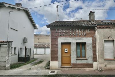 photograph “IX.2024 — Faces of home, 227” par David Farreny — www.farreny.net — France, Occitanie, Tarn-et-Garonne, Montauban, ville, city, rue, street, maisons, houses, enseigne, sign, vieille, vieux, old, magasin, shop, store, commerce, fermé, closed down, boulangerie, pâtisserie, bakery, pastry, porte, door, bois, wood, fenêtres, windows, toits, roofs, tuiles, tiles, câbles, cables, fils, wires, portail, gate, métal, metal, garages, nuages, clouds, passage, allée, alley, trottoir, pavement, boîte à lettres, mailbox, cheminées, chimneys, antenne, antenna, numéro, number, 5, domicile, home