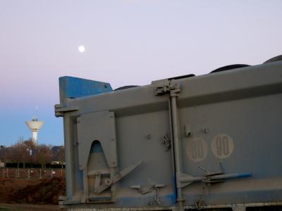 photograph “XII.2013” par David Farreny — www.farreny.net — France, château d'eau, watertower, béton, concrete, maisons, houses, lune, moon, soir, evening, camion, truck, lorry, benne, dump, tipper, pneus, tires, tyres, métal, metal, ciel, sky, 80, 90, speed limits, vitesses limitées, poussière, dust, arbres, trees, Occitanie, Aveyron, Rouergue, Olemps