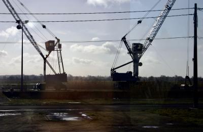 photograph “I.2006” par David Farreny — www.farreny.net — France, Nantes-Bordeaux, train, paysage, landscape, vitre, verre, glass, ciel, sky, nuage, clouds, grues, cranes, métal, metal, vitesse, speed, voie ferrée, railway, voyage, travel, trip, cabines, cabins, arbres, trees, lampadaires, lamps, câbles, cables, fils, wires, flaques, eau, water, puddles, chaînes, chaine, échelles, ladders