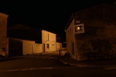 photograph “V.2020 — At night” par David Farreny — www.farreny.net — France, soir, evening, nuit, night, rue, street, maisons, houses, village, carrefour, crossroads, bitume, blacktop, asphalte, asphalt, miroir, mirror, plaque, plate, voiture, car, fenêtres, windows, porte, door, portail, gate, garage, lumière, light, Occitanie, Gascogne, Gers, Jegun