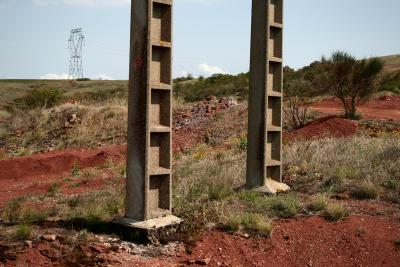 photograph “VIII.2011” par David Farreny — www.farreny.net — France, Occitanie, Rouergue, Aveyron, Camarès, rougier, poteaux, électriques, electricity, poles, herbe, grass, terre, sol, rouge, red, earth, soil, arbuste, shrub, arbre, tree, béton, concrete, ciment, cement, pylône, pylon, cailloux, stones, vide, empty, emptiness, métal, metal