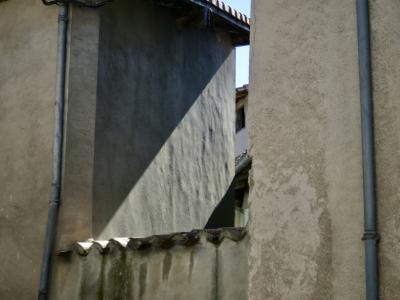 photograph “VI.2015” par David Farreny — www.farreny.net — France, Occitanie, Tarn, Sorèze, mur, wall, ciment, cement, renfoncement, niche, recoin, recess, maisons, houses, intervalle, interval, interstice, gap, gouttières, drainpipes, métal, metal, tuiles, tiles, toit, roof, soleil, sun, oblique, lumière, light, espace, space