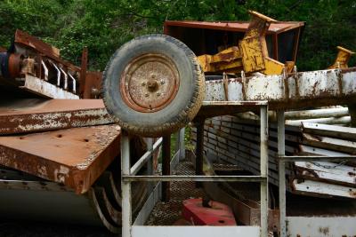 photograph “V.2006” par David Farreny — www.farreny.net — France, Occitanie, Aveyron, Rouergue, Salles-la-Source, chantier, mine, mining site, structures, métal, metal, roue, wheel, pneu, tire, tyre, rouille, rust, rusty, profusion, machines, arbres, trees, tas, pile, heap