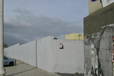 photograph “II.2020” par David Farreny — www.farreny.net — Portugal, Lisbonne, Lisboa, Lisbon, ville, city, capitale, capital, rue, street, mur, wall, poteau, pole, post, voiture, car, ombre, shadow, immeuble, bâtiment, building, jaune, yellow, affiches, posters, fil, wire, câble, cable, ciel, sky, nuages, clouds, Perigo, trottoir, pavement, pierre, stone, coin, angle, corner