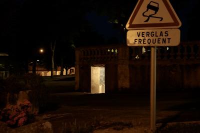 photograph “V.2020 — At night” par David Farreny — www.farreny.net — France, Occitanie, Gascogne, Gascony, Gers, Jegun, nuit, night, soir, evening, village, panneau, sign, routier, roadsign, verglas fréquent, frequent black ice, voiture, glissante, slipping, car, logo, place, square, arbres, trees, WC, toilettes, toilets, publiques, public, pissotière, urinal, lumière, light, carrelage, tiling, rambarde, guardrail, lampadaire, lamp, fleurs, flowers, maison, house, rue, street