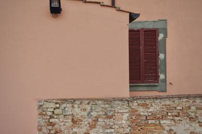 photograph “X.2019 — Faces of home, 240” par David Farreny — www.farreny.net — Italie, Italia, Italy, Toscane, Toscana, Tuscany, Florence, Firenze, Certaldo, maison, house, mur, wall, brique, brick, ciment, cement, lampe, lamp, projecteur, floodlight, tuiles, tiles, fenêtre, window, volets, shutters, bois, wood, rose, pink, saumon, salmon, persiennes, louvers, domicile, home