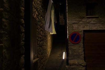 photograph “VII.2021” par David Farreny — www.farreny.net — Andorre, Andorra, Canillo, ville, city, bourgade, town, soir, evening, nuit, night, maisons, houses, pierre, stone, ruelle, alley, murs, walls, garage, portail, gate, panneau, routier, sign, roadsign, draps, sheets, bed sheets, lampe, lamp, néon, neon, lumière, light, fenêtre, window, volets, shutters, bois, wood, angle, coin, corner, passage, corde à linge, washing line