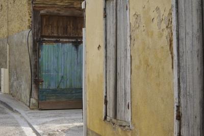 photograph “III.2021” par David Farreny — www.farreny.net — France, Occitanie, Gascogne, Gers, Éauze, rue, street, ville, city, trottoir, pavement, portail, gate, bois, wood, bleu, blue, vert, green, turquoise, mur, wall, pierre, stone, fenêtres, windows, volets, shutters, câbles, cables, fils, wires, goulottes, cadenas, lock, charnières, hinges, rouille, rust, rusty, coin, corner, angle