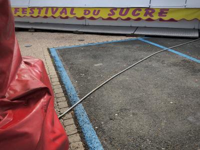 photograph “IV.2018 — Sweets” par David Farreny — www.farreny.net — France, fête foraine, funfair, bâche, cover, tarp, tarpaulin, rouge, red, plastique, plastic, câble, wire, fil, cable, électrique, electricity, power, bitume, blacktop, asphalte, asphalt, attraction, enseigne, sign, auvent, awning, Festival du sucre, Sugar festival, métal, metal, Occitanie, Gascogne, Gers, Auch