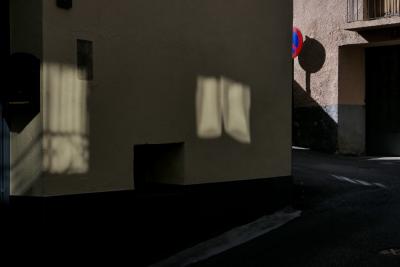 photograph “X.2021” par David Farreny — www.farreny.net — Andorre, Andorra, Canillo, ville, city, rue, street, paroi, mur, wall, pénombre, darkness, sombre, dark, ombre, shadow, reflets, reflections, lumière, light, fenêtres, windows, balcon, balcony, portail, gate, panneau, sign, routier, roadsign, coin, corner, angle, bitume, blacktop, asphalt, asphalte, porte, door, rambarde, guardrail, métal, metal