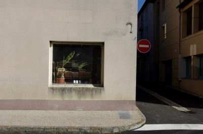 photograph “II.2014” par David Farreny — www.farreny.net — France, ville, city, rue, street, magasin, shop, store, fenêtre, window, vitrine, verre, vitre, glass, trottoir, pavement, panneau, roadsign, sens interdit, one-way, mur, wall, plantes, plants, cageots, crates, maisons, houses, Occitanie, Aveyron, Rouergue, Réquista