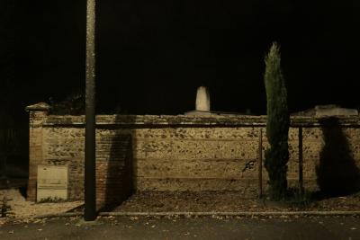 photograph “XI.2024 — At night” par David Farreny — www.farreny.net — France, Occitanie, Haute-Garonne, Bérat, cimetière, cemetery, nuit, night, soir, evening, mur, wall, brique, bricks, galets, pebbles, tombe, tomb, cyprès, cypress, arbre, tree, trottoir, pavement, poteau, post, pole, ombres, shadows